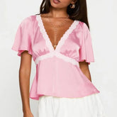 Model displaying a short lace trim flare short sleeve top with a V-neck.